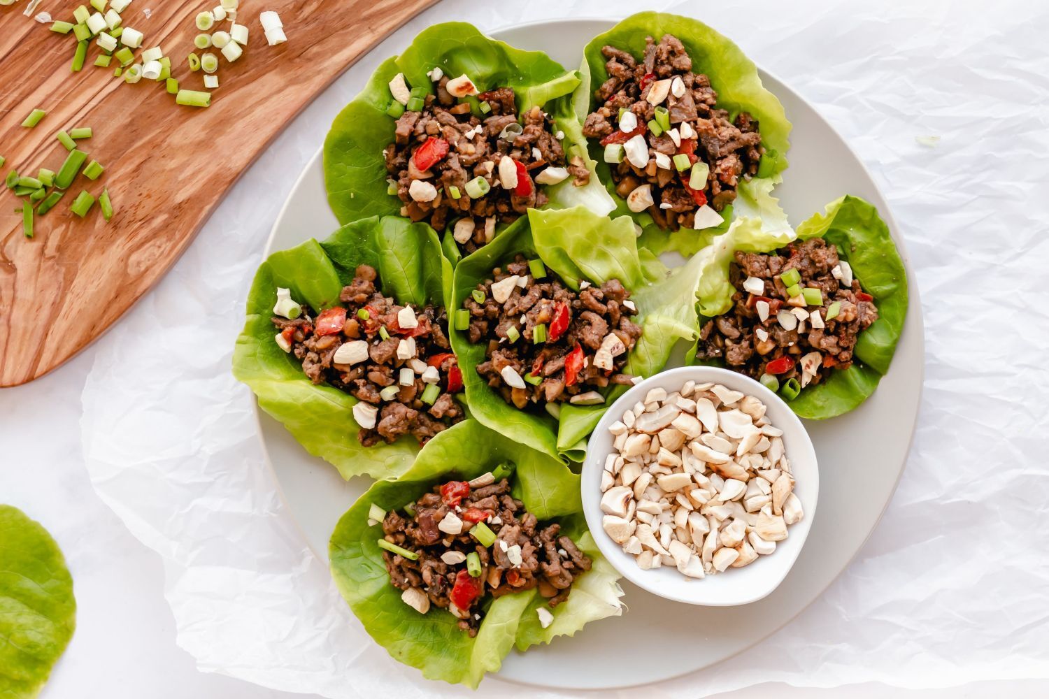 Asian Ground Beef Lettuce Wraps Asian ground beef lettuce wraps served on a plate with beef, mushrooms, peppers, and cashews wrapped in butter lettuce.