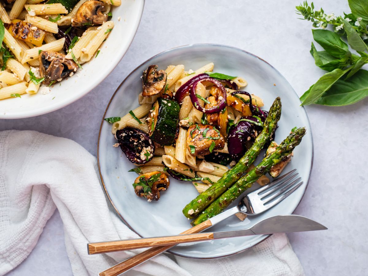 Healthy Lunch Recipes Grilled vegetable pasta salad with balsamic dressing, mushrooms, zucchini, asparagus, red onion, and herbs on a plate.