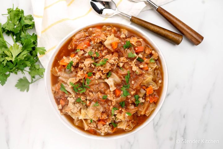 Healthy Cabbage Soup Healthy cabbage soup with cabbage, ground turkey, tomatoes, and cauliflower rice in a bowl.