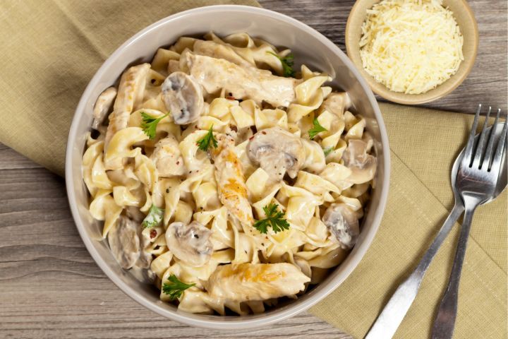 One Pot Creamy Chicken and Mushroom Pasta Chicken and Mushroom Pasta in a creamy sauce in a pan with a napkin on the side.