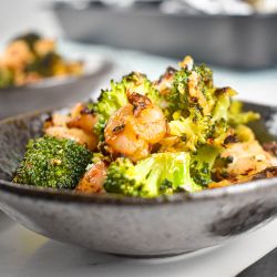 Garlic Parmesan Roasted Shrimp and Broccoli Garlic Roasted shrimp and broccoli in a bowl with shredded cheese, lemon, and red pepper flakes.