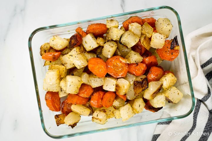 Roasted Carrots and Turnips Roasted carrots and turnips with herbs in a glass container.