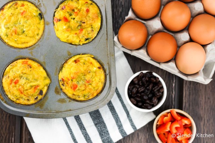 Southwest Black Bean Egg Muffins Black bean egg muffins in a muffin tin with eggs, black beans, and red pepper on the side.