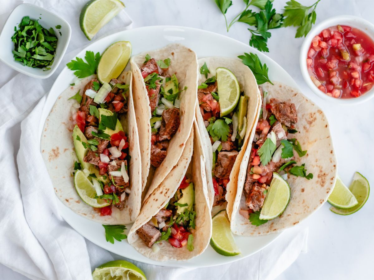 Healthy Taco Recipes Steak tacos on flour tortillas with cilantro, onion, salsa, and lime.